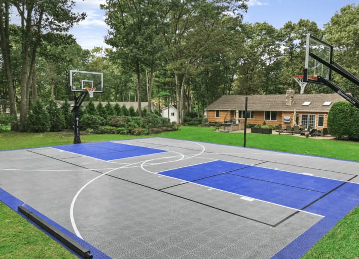 Finished Concrete Basketball Court job in Huntersville, North Carolina by Local Concrete Co — clean control-joint pattern, smooth troweled surface, full property protection during pour.