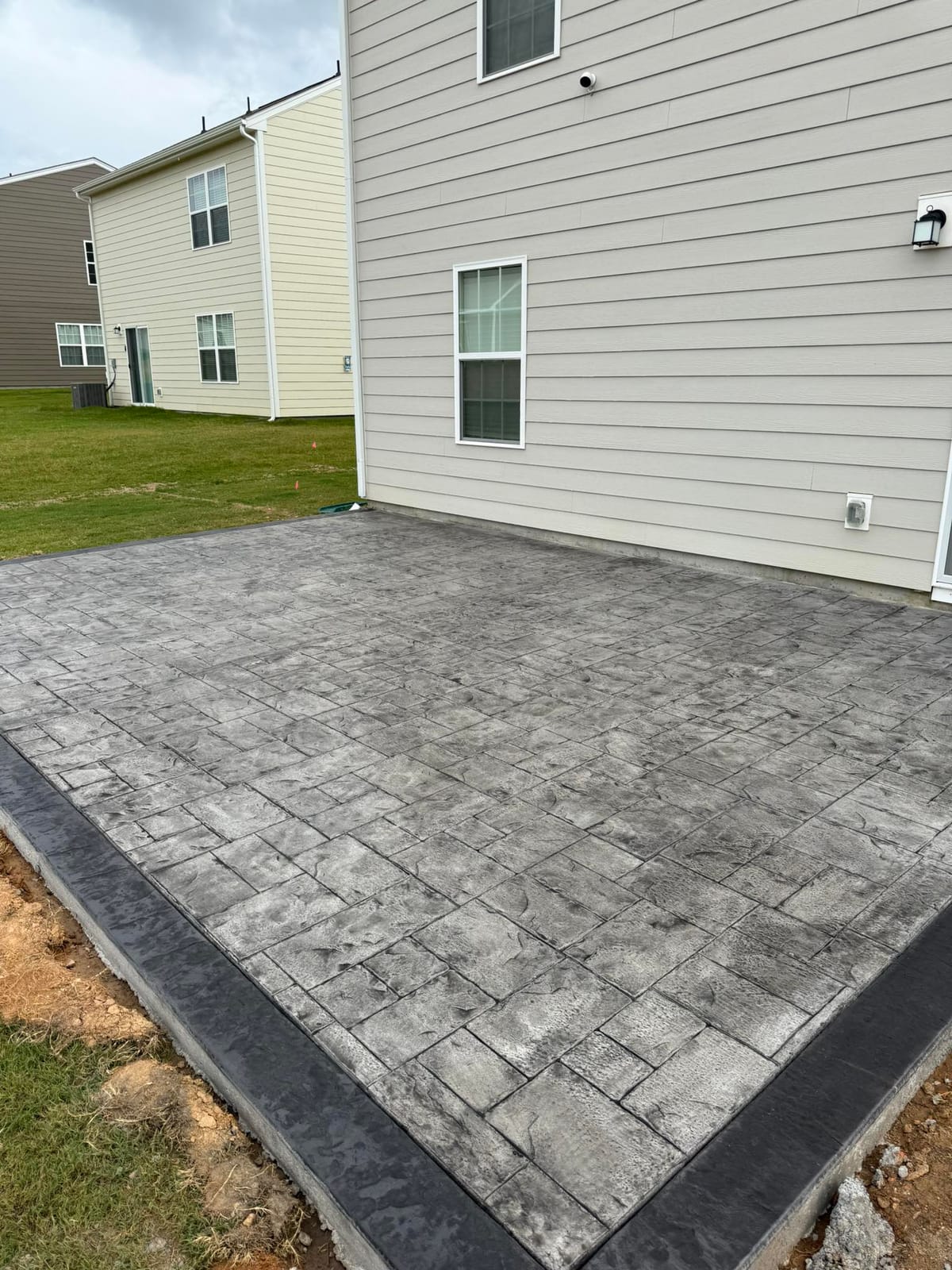 Finished Stamped Concrete job in Huntersville, North Carolina by Local Concrete Co — clean control-joint pattern, smooth troweled surface, full property protection during pour.